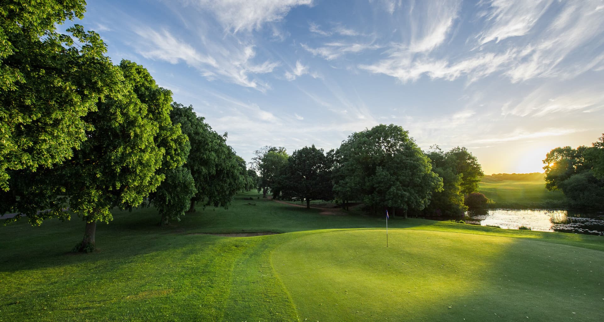 A green at The Hertfordshire Golf & Country Club at sunset